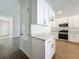 Bright kitchen with white cabinets, stainless steel appliances, light countertop, and light vinyl floors at 1112 W Line St, Leesburg, FL 34748