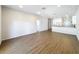 Bright living room with wood-look flooring, offering a view of the open-concept kitchen at 1112 W Line St, Leesburg, FL 34748