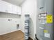 Neat utility room with built-in cabinets, modern water heater, and laundry hookups for convenience at 1112 W Line St, Leesburg, FL 34748
