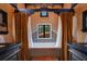 Luxurious bathroom featuring tile accents, dark wood vanities, and a tub under a window at 1141 S Osceola Ave, Orlando, FL 32806