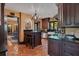 Rustic kitchen with dark wood cabinetry, terracotta tile flooring, and an island with bar stool seating at 1141 S Osceola Ave, Orlando, FL 32806