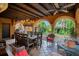 Relaxing covered patio with elegant chandelier, outdoor dining, and lush tropical landscaping at 1141 S Osceola Ave, Orlando, FL 32806