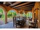 Covered outdoor dining area with a large table, chandelier, columns, and lush landscaping at 1141 S Osceola Ave, Orlando, FL 32806