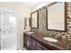 Elegant bathroom featuring a soaking tub, decorative tile, and ornate double vanity with marble countertop at 12543 Waterhaven Cir, Orlando, FL 32828