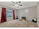 Spacious carpeted bedroom with ceiling fan and natural light from the large window at 131 Woodbury Pines Cir, Orlando, FL 32828