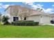 Two-story home with a two-car garage, well-kept lawn, and mature tree at 131 Woodbury Pines Cir, Orlando, FL 32828