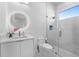 Modern bathroom featuring a glass shower, sleek white vanity, and circular illuminated mirror at 15843 Vetta Dr, Bella Collina, FL 34756