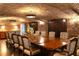 Spacious dining room with exposed brick ceiling and a large wooden table at 15843 Vetta Dr, Bella Collina, FL 34756