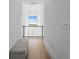 Bright hallway features wood floors, bench seating, and a modern railing overlooking the landscape at 15843 Vetta Dr, Bella Collina, FL 34756
