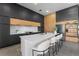 Modern kitchen with an island, white countertops, dark cabinetry, stainless steel appliances, and barstool seating at 15843 Vetta Dr, Bella Collina, FL 34756