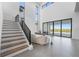 Bright living room with high ceilings, a staircase, and large sliding glass doors to the patio at 15843 Vetta Dr, Bella Collina, FL 34756