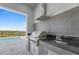 Built-in outdoor kitchen featuring a grill, sink, and mini fridge with a view of the swimming pool at 15843 Vetta Dr, Bella Collina, FL 34756