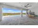 An outdoor area that features a built-in kitchen, dining area, fan, and a view of the pool and nature at 15843 Vetta Dr, Bella Collina, FL 34756