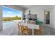 A beautiful outdoor area featuring a built-in kitchen, dining area, and a view of the pool and nature at 15843 Vetta Dr, Bella Collina, FL 34756