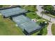 Aerial view of well-maintained tennis courts surrounded by lush landscaping at 15843 Vetta Dr, Bella Collina, FL 34756