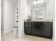 Bathroom showcasing a granite countertop, dark cabinets, tile floors, and a toilet at 16310 Rock Coast Dr, Winter Garden, FL 34787