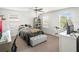 Bedroom with a desk, bench, bookshelf, large windows, fan, carpeted floor, and a queen-sized bed at 16310 Rock Coast Dr, Winter Garden, FL 34787