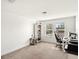 Bright bedroom featuring neutral carpet, white walls, natural light, and a desk area at 16310 Rock Coast Dr, Winter Garden, FL 34787