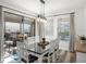 Light and airy dining room with a modern chandelier, large windows, glass doors and a white dining set at 16310 Rock Coast Dr, Winter Garden, FL 34787