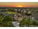 A two-story home with a neutral exterior paint, two car garage, and sunset in the background at 16310 Rock Coast Dr, Winter Garden, FL 34787