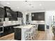 Modern kitchen featuring black cabinetry, stainless steel appliances, and center island with barstool seating at 16310 Rock Coast Dr, Winter Garden, FL 34787
