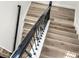 Staircase featuring modern wood steps with white risers and a dark metal banister at 16310 Rock Coast Dr, Winter Garden, FL 34787