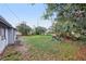 Home features a backyard with a grassy lawn and mature trees at 1834 Willie Mays Pkwy, Orlando, FL 32811