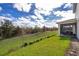 Enjoy the expansive backyard with lush green grass, a well-maintained fence, and a view of the screen patio at 187 Aces High Ln, Davenport, FL 33896