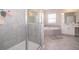 Bathroom showcases a glass-enclosed shower and a large bathtub with tiled surround at 187 Aces High Ln, Davenport, FL 33896