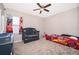 This playful bedroom features a grey crib, 'Cars' themed toddler bed, ceiling fan, and bright window at 187 Aces High Ln, Davenport, FL 33896