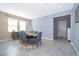 Inviting dining room with a large window, neutral walls, and stylish gray tile flooring at 187 Aces High Ln, Davenport, FL 33896