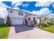 Charming two-story home with a brick driveway, landscaped yard, and a covered entryway at 187 Aces High Ln, Davenport, FL 33896