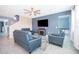 Living room with tile flooring, ceiling fan, fireplace, and stylish blue sofa set at 187 Aces High Ln, Davenport, FL 33896