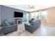 Living room with tile flooring, fireplace, ceiling fan, and comfortable blue sofa set at 187 Aces High Ln, Davenport, FL 33896