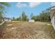 A spacious, fenced backyard with plenty of room to play and a storage shed at 25 Maple Crse, Ocklawaha, FL 32179