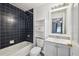 Bathroom featuring blue tile in the shower and a white storage cabinet at 25 Maple Crse, Ocklawaha, FL 32179