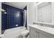Cozy bathroom featuring blue tile in the shower and a modern vanity with gray cabinets at 25 Maple Crse, Ocklawaha, FL 32179