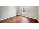 Bright bedroom featuring a window, wood-look floors, and neutral-toned walls at 25 Maple Crse, Ocklawaha, FL 32179