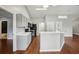 Open kitchen area boasting an eat-in bar, gray cabinets, black appliances, and wood-look floors at 25 Maple Crse, Ocklawaha, FL 32179