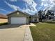 Charming single-story home featuring a well-maintained lawn, attached garage, and a welcoming entrance at 324 Anchovie Ct, Kissimmee, FL 34759