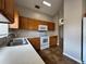 Well-lit kitchen features wooden cabinets, white appliances, tile flooring, and a stainless steel sink at 324 Anchovie Ct, Kissimmee, FL 34759