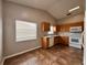 Bright kitchen with ample sunlight features wood cabinets, white appliances, and tile floor at 324 Anchovie Ct, Kissimmee, FL 34759