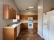 Functional kitchen features white appliances, wood cabinets, and tile flooring at 324 Anchovie Ct, Kissimmee, FL 34759