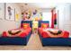 This themed bedroom features two twin beds with colorful decor and playful wall art at 3432 Lilac Way, Davenport, FL 33897