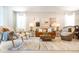 Bright living room with a leather couch, eclectic chairs, artwork, and a patterned rug at 3432 Lilac Way, Davenport, FL 33897
