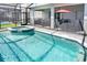 Relax in style with a screened-in pool and spa, complete with an outdoor seating and dining area at 3432 Lilac Way, Davenport, FL 33897