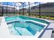A sparkling pool and jacuzzi are enclosed in a screened patio at 3432 Lilac Way, Davenport, FL 33897