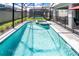 A luxurious pool and jacuzzi area is enclosed with a secure screened-in pool fence at 3432 Lilac Way, Davenport, FL 33897