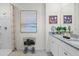Bright bathroom featuring a double sink vanity with granite countertop and framed artwork at 3609 Salvia Ct, Tavares, FL 32778