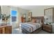 Bright bedroom with a large window, stylish bed, natural textures and decor, and wood accents at 3609 Salvia Ct, Tavares, FL 32778